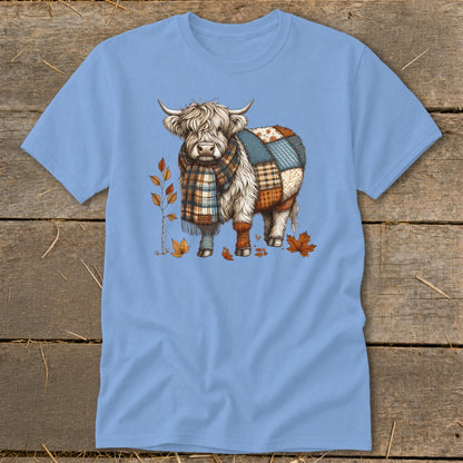 Highland cow with patchwork body and plaid scarf surrounded by autumn leaves.