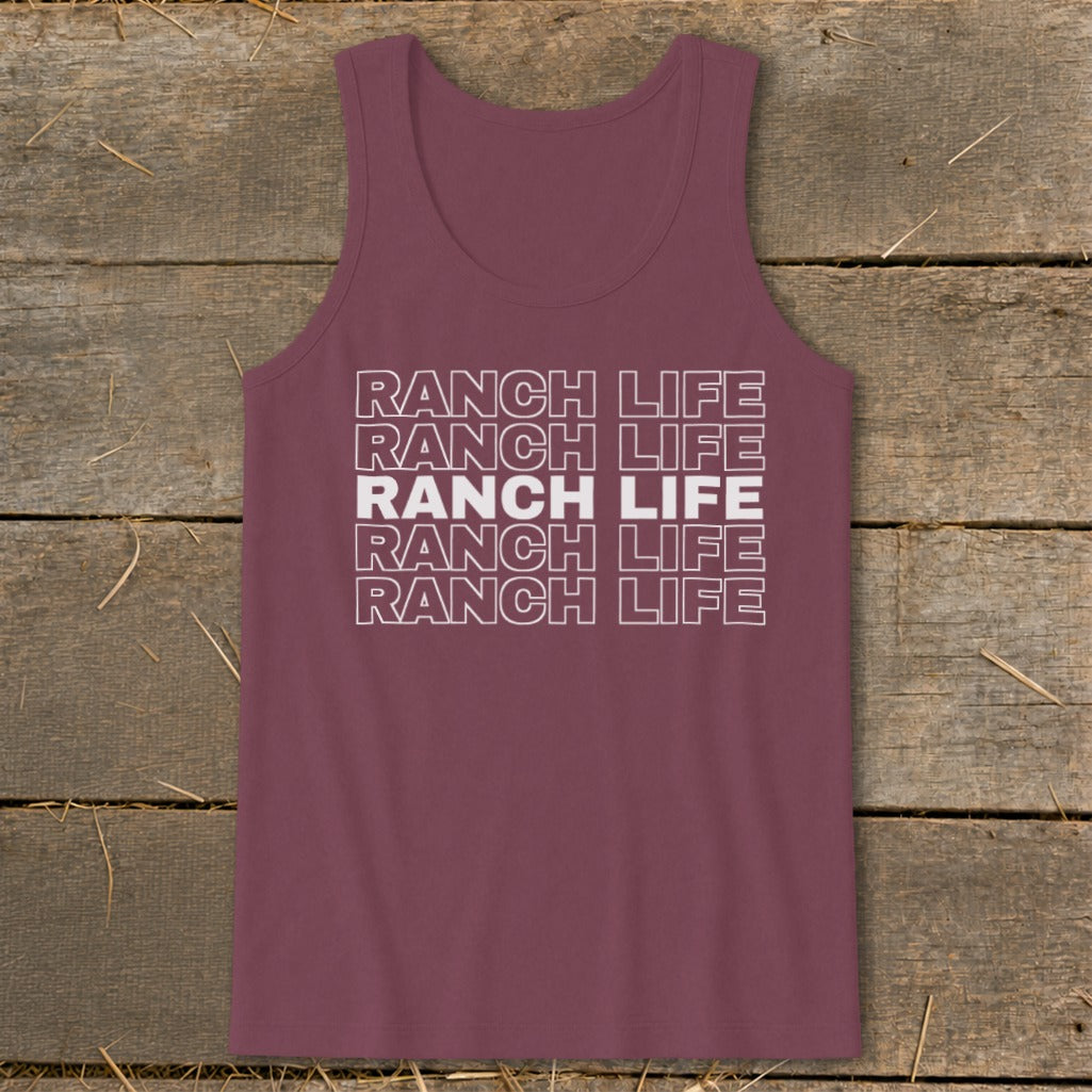 A maroon tank top with white block text reading Ranch Life stacked five times, displayed on a wooden surface.