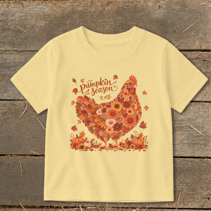 Yellow t-shirt with floral chicken and "pumpkin season" text, surrounded by pumpkins and leaves.