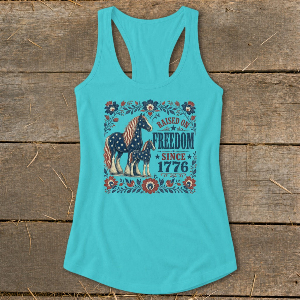 Turquoise tank top with horses and "Raised on Freedom Since 1776" text.