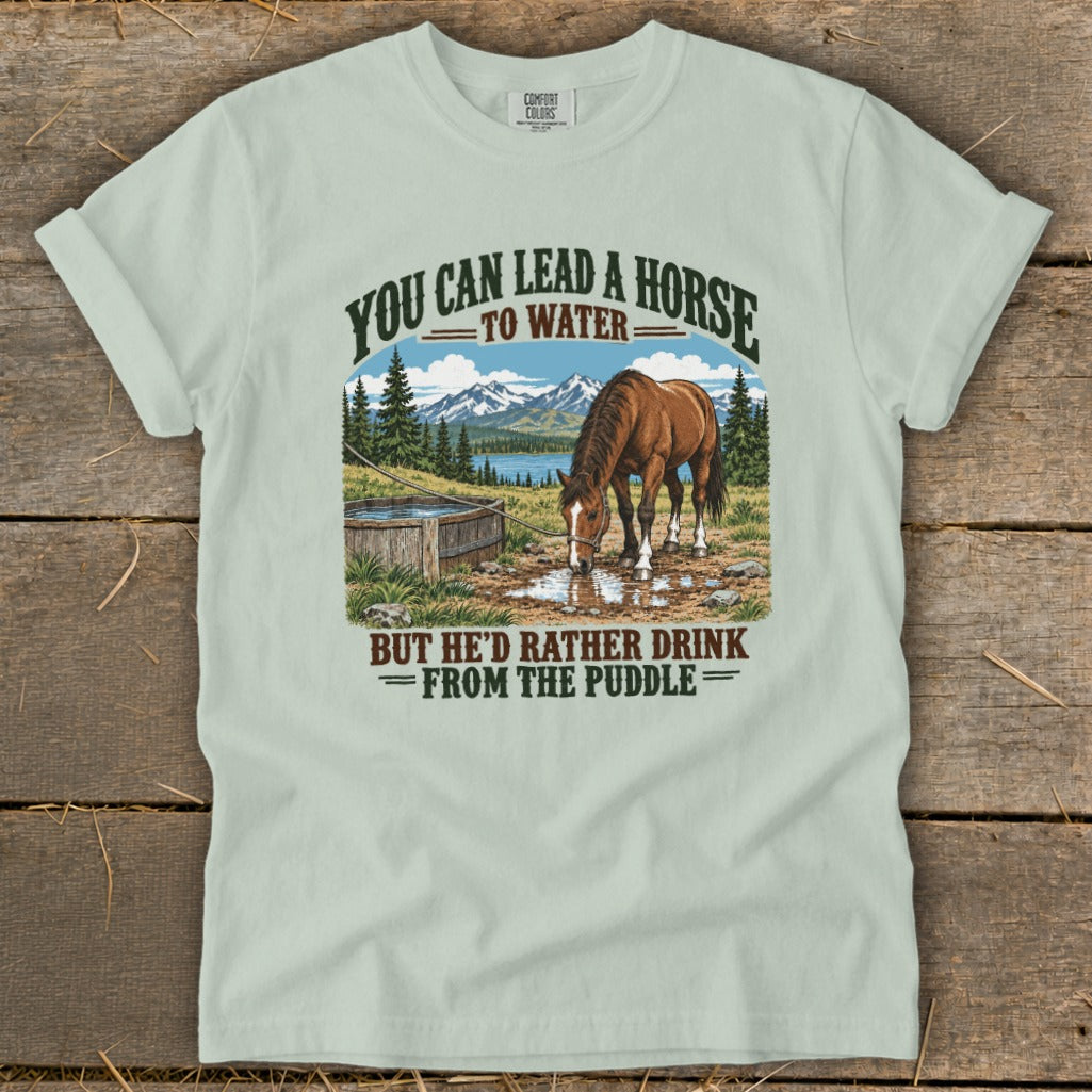 A light green t-shirt with a vintage graphic of a horse drinking from a puddle.