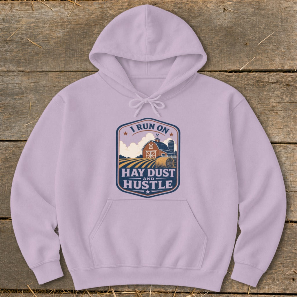Lilac hoodie with "I Run On Hay Dust and Hustle" farm graphic.
