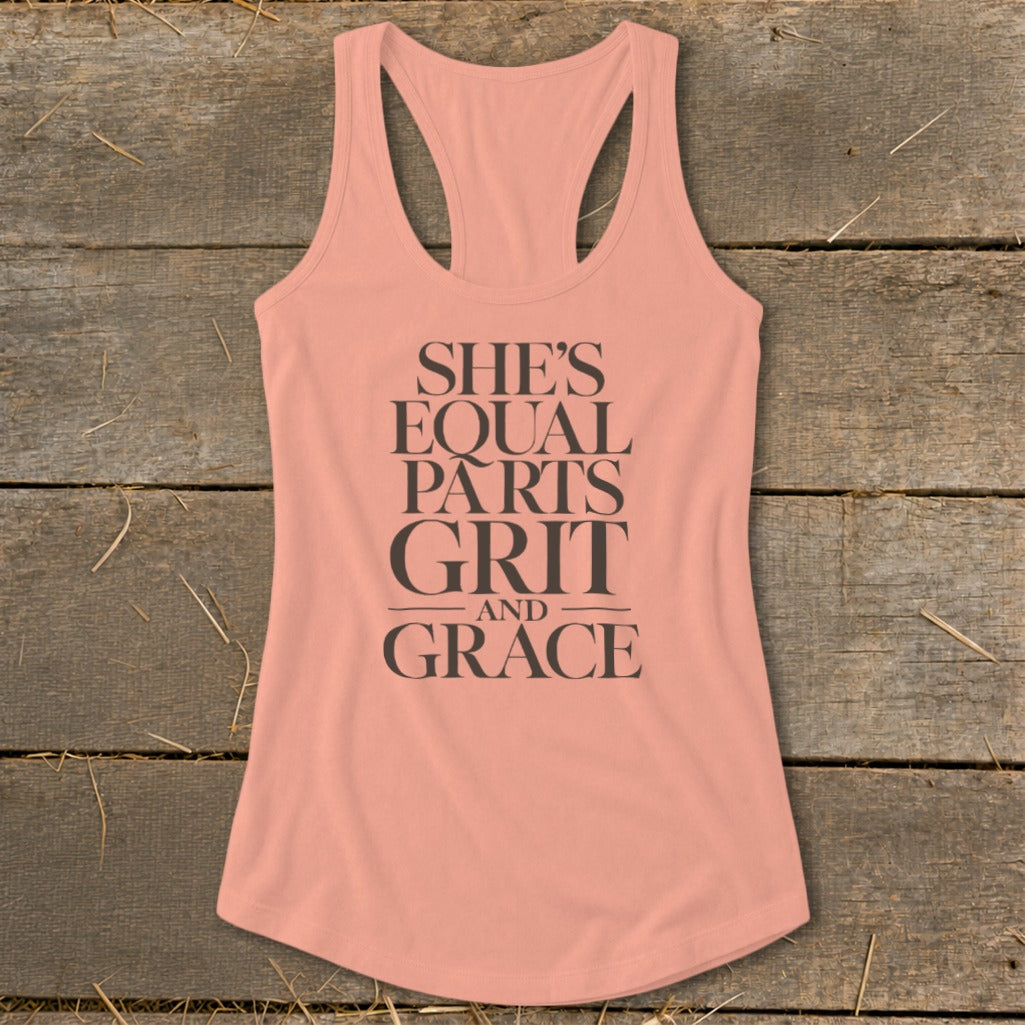 Peach tank top with dark text reading "SHE'S EQUAL PARTS GRIT AND GRACE."