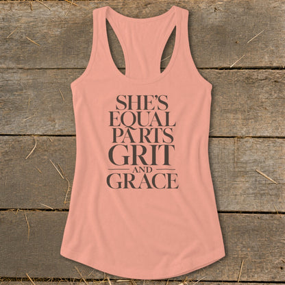 Peach tank top with dark text reading "SHE'S EQUAL PARTS GRIT AND GRACE."