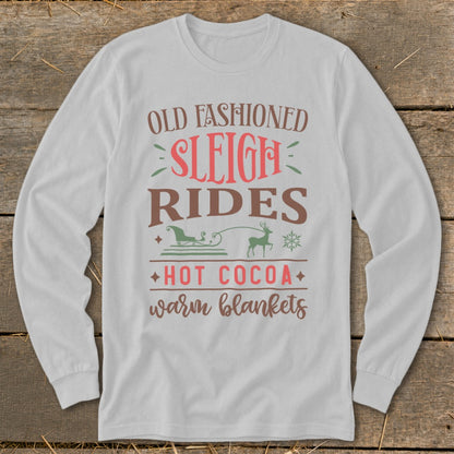 White long-sleeve shirt with "Old Fashioned Sleigh Rides Hot Cocoa Warm Blankets" text.