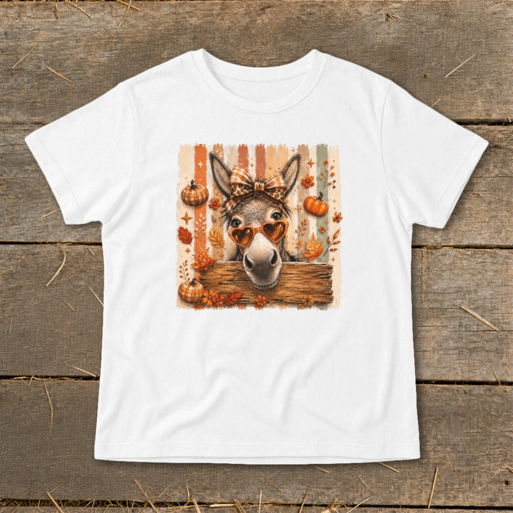 Donkey with heart sunglasses and bow peeking over wood, surrounded by pumpkins and leaves.