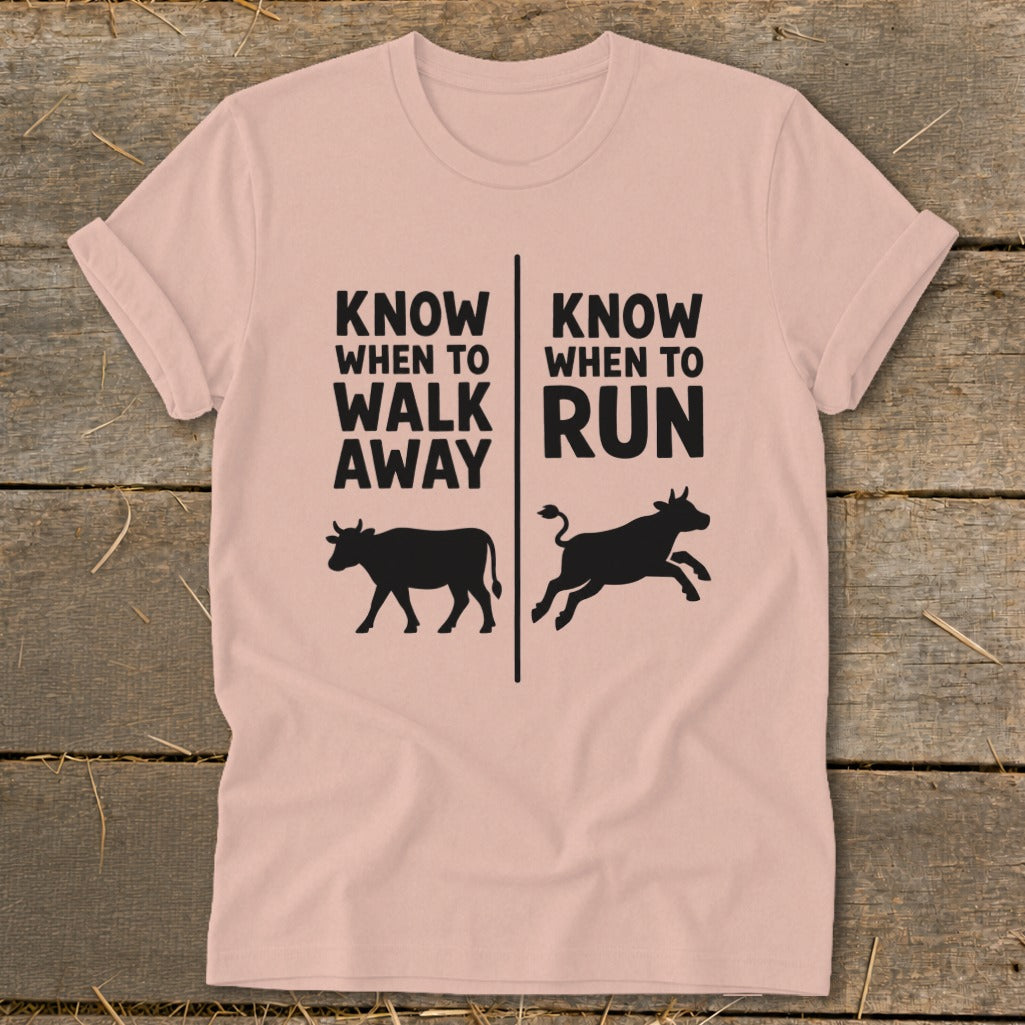 Pink t-shirt with text "Know When to Walk Away" and cow, and "Know When to Run" and running cow.