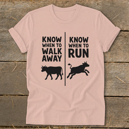 Pink t-shirt with text "Know When to Walk Away" and cow, and "Know When to Run" and running cow.