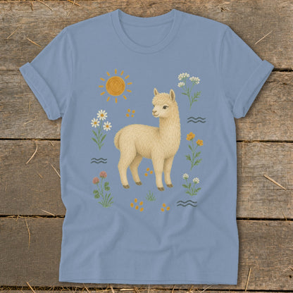 Light blue t-shirt with a cream-colored alpaca, sun, and floral design.
