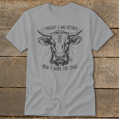 Gray t-shirt with a sketch of a cow and the text "I thought I was retired - Now I work for cows."