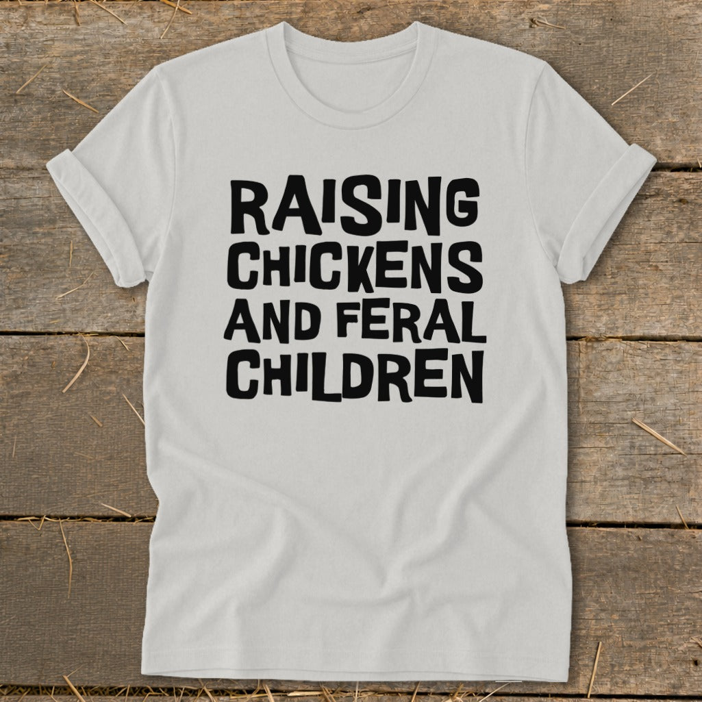 White t-shirt with black text "Raising Chickens And Feral Children".