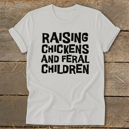White t-shirt with black text "Raising Chickens And Feral Children".