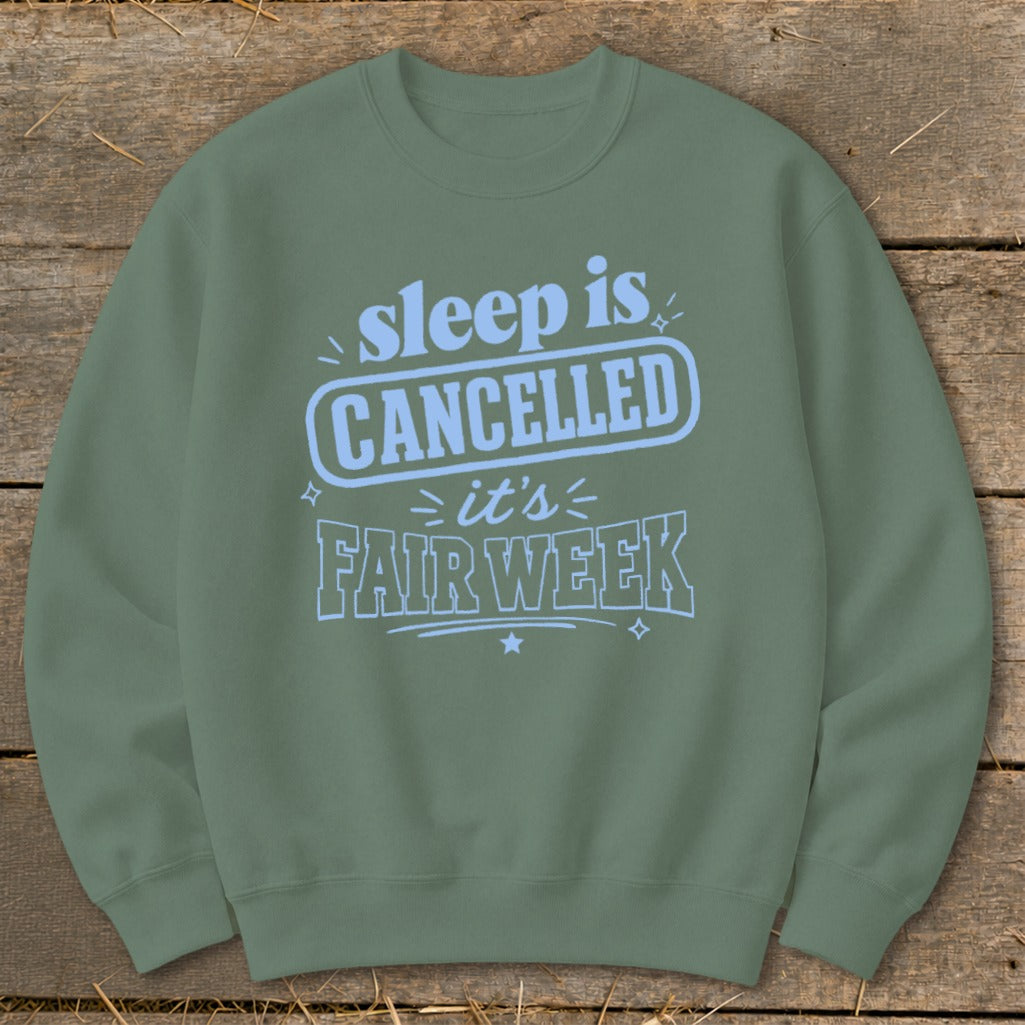 Olive green sweatshirt with "sleep is CANCELLED it's FAIR WEEK" text design.