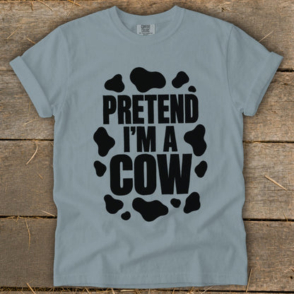 Light blue t-shirt with black text "PRETEND I'M A COW" and cow spots.
