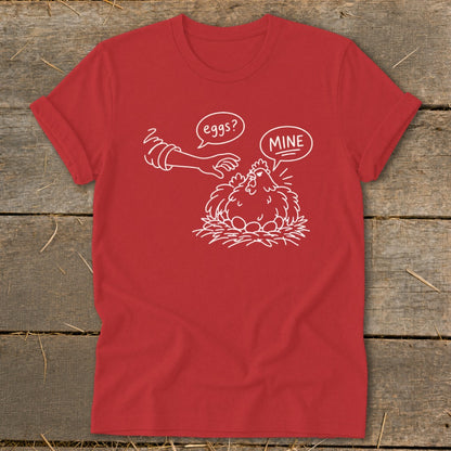 Red t-shirt with white line art of a chicken protecting its eggs, saying "MINE".