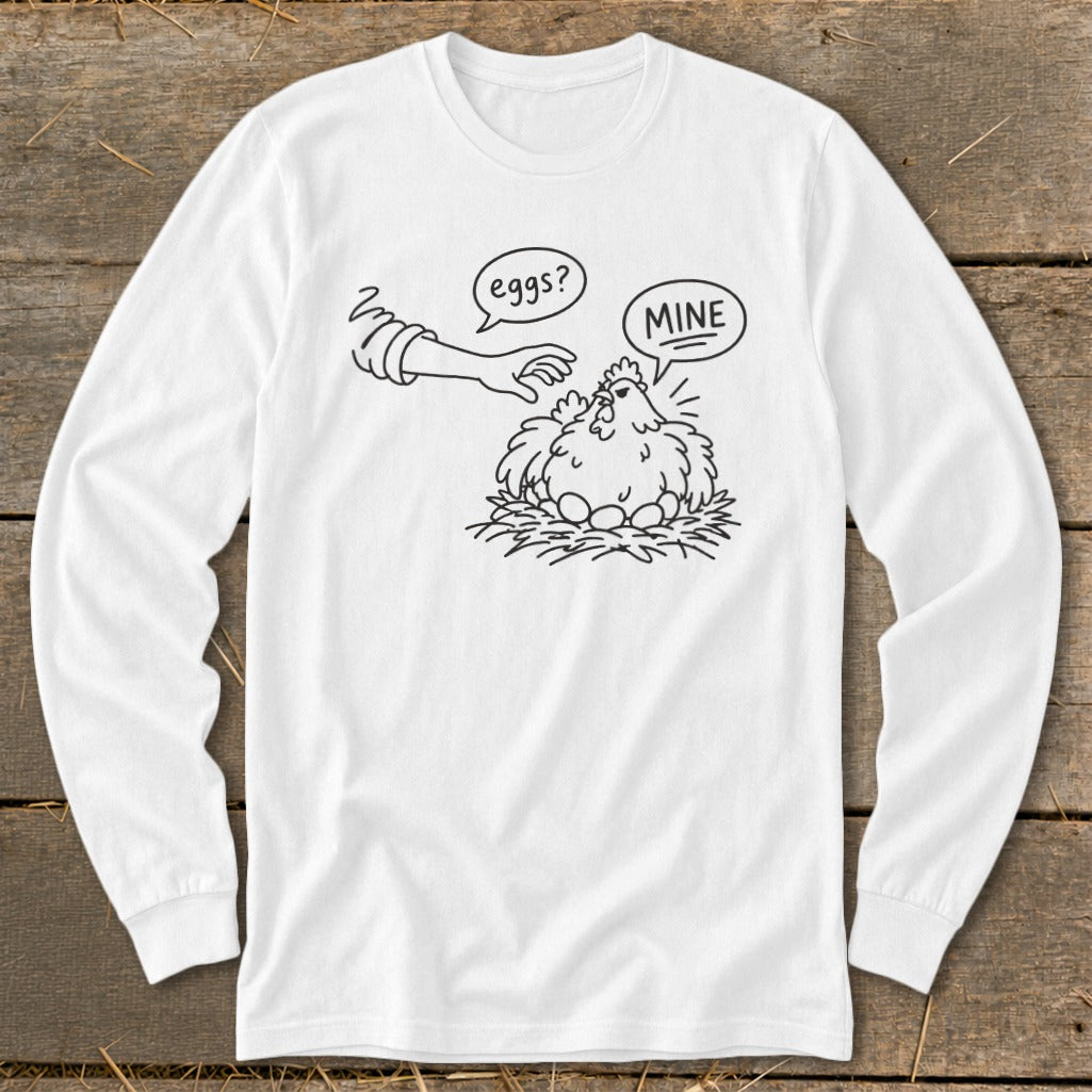 Line art on white long-sleeve shirt: hen guarding eggs, hand asks "eggs?", hen replies "MINE".