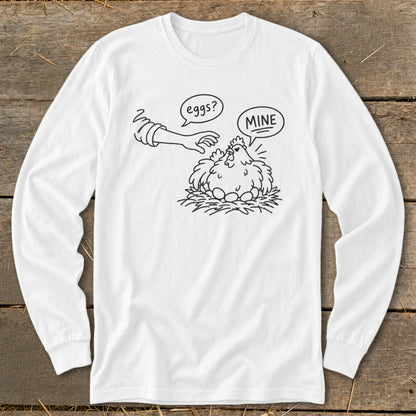 Line art on white long-sleeve shirt: hen guarding eggs, hand asks "eggs?", hen replies "MINE".