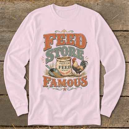 Feed Store Famous graphic on a pink long-sleeve shirt with a chicken, feed bag, and scoop.