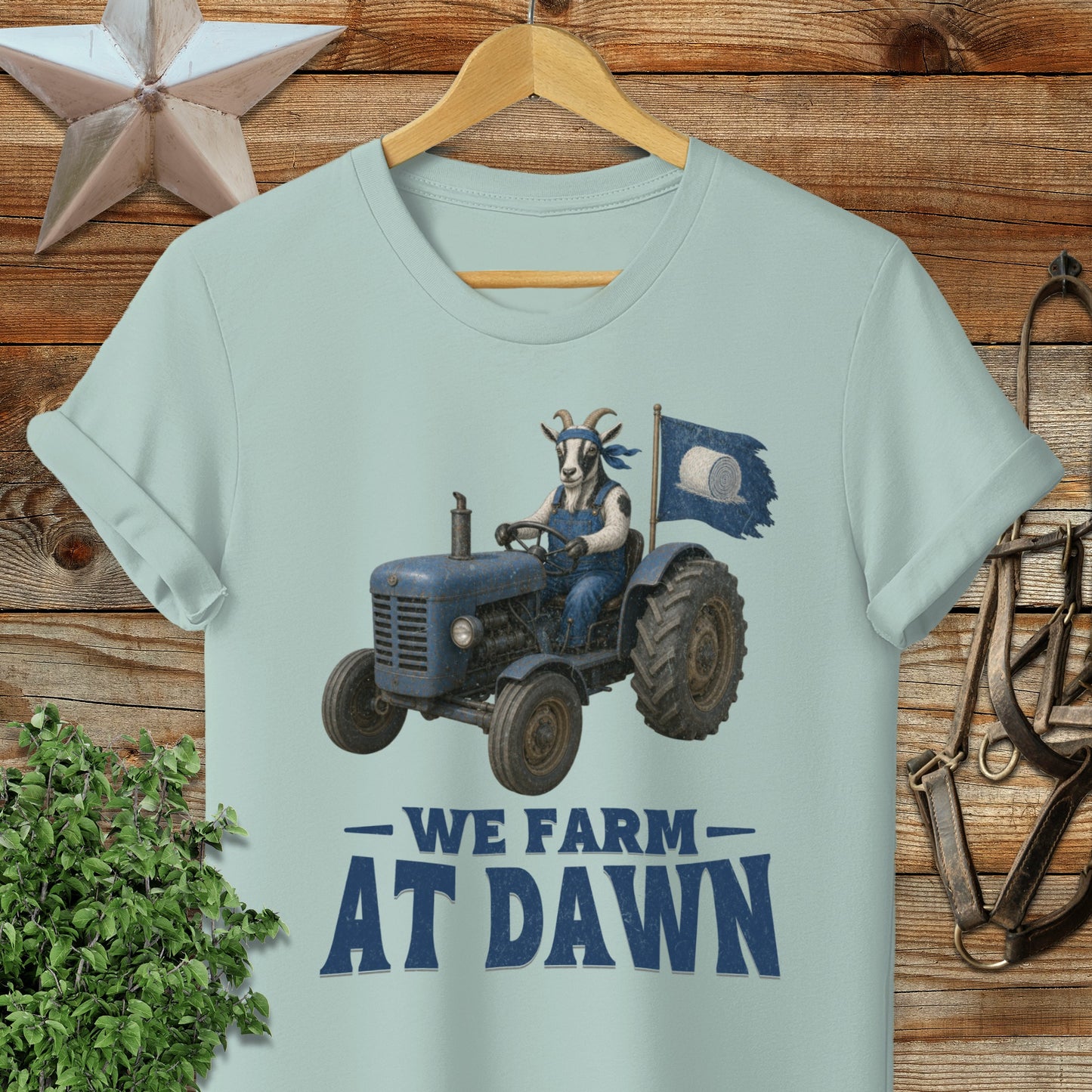 Blue tractor with goat driver, flag, and text "We Farm At Dawn".