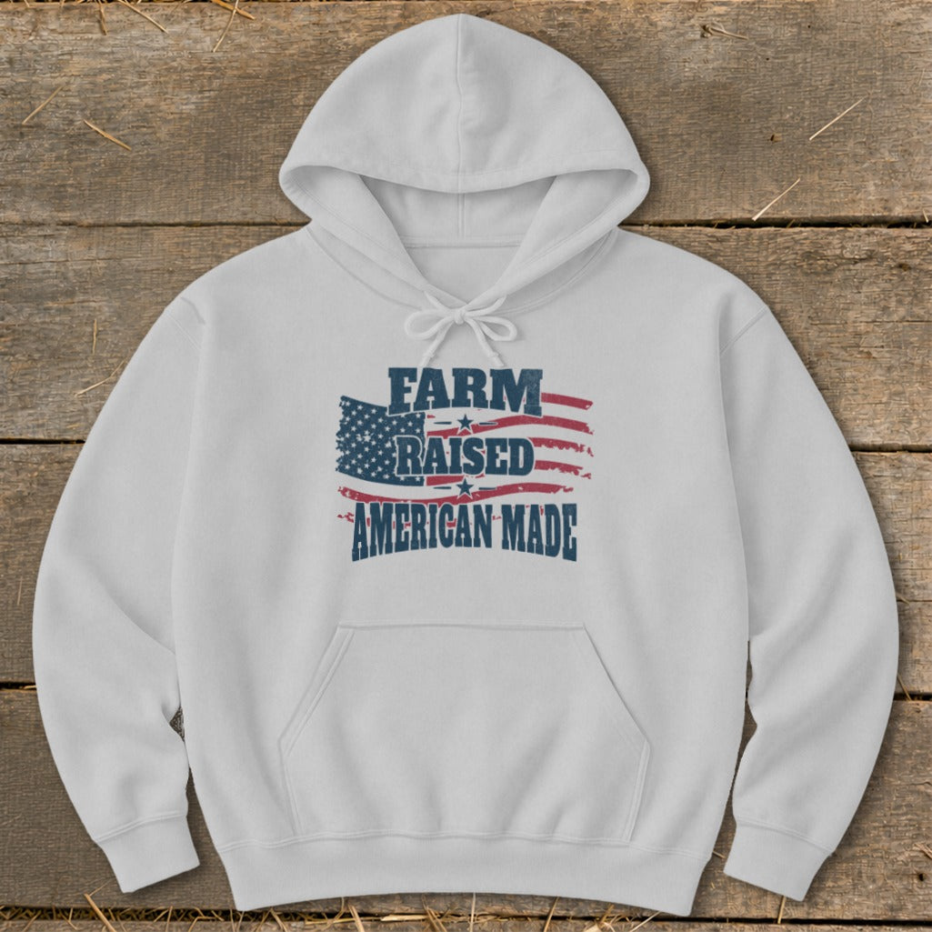 White hoodie with distressed American flag graphic and text "FARM RAISED AMERICAN MADE".