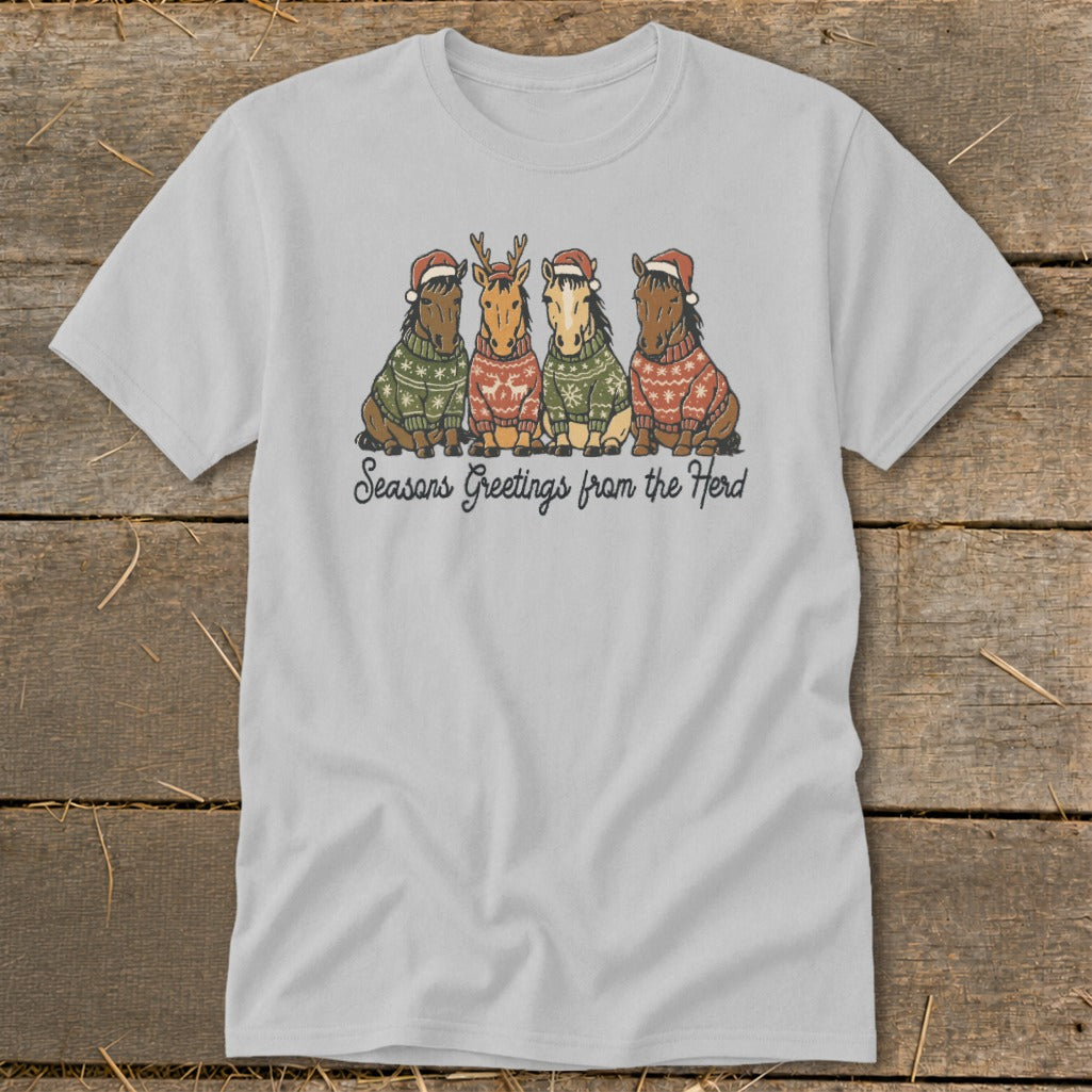 Light grey t-shirt with four horses in Christmas sweaters and Santa hats, with text "Seasons Greetings from the Herd".