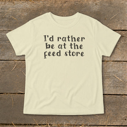 Light yellow t-shirt with black text that reads "I'd rather be at the feed store".