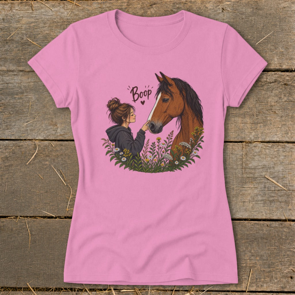 Girl with messy bun gently touches nose to horse's nose, with "Boop" text.