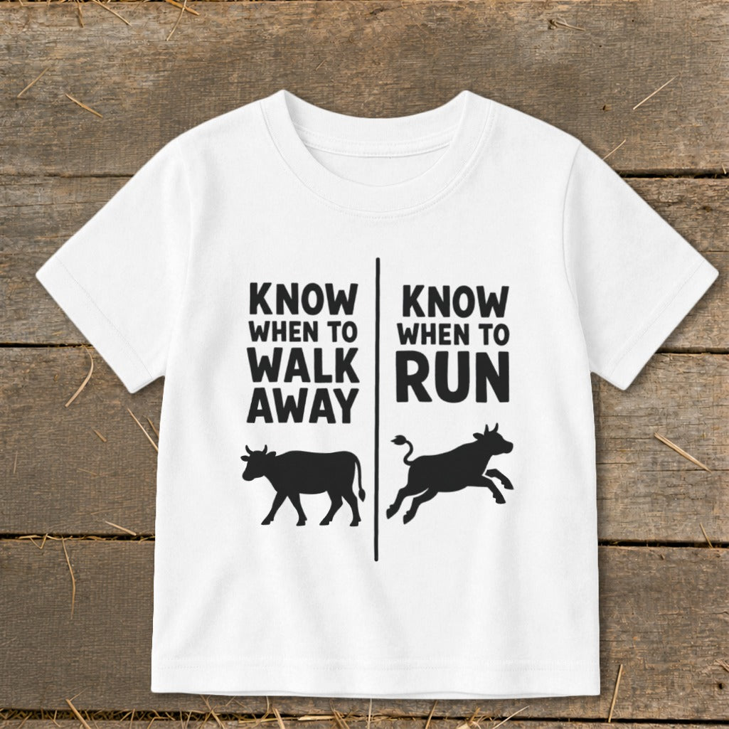 White t-shirt with black text and cow graphics: "Know When To Walk Away" and "Know When To Run".