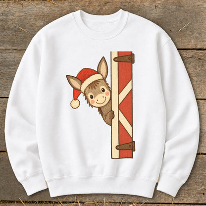 White sweatshirt with a cartoon donkey wearing a Santa hat peeking from behind a barn door.