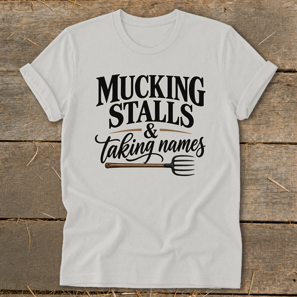 White t-shirt with "Mucking Stalls & Taking Names" and a pitchfork graphic.