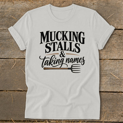 White t-shirt with "Mucking Stalls & Taking Names" and a pitchfork graphic.