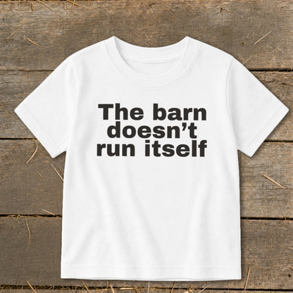 White t-shirt with black text reading "The barn doesn't run itself".