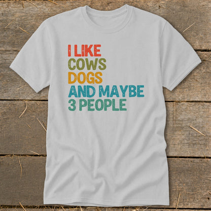 White t-shirt with text "I LIKE COWS DOGS AND MAYBE 3 PEOPLE" in colorful lettering.