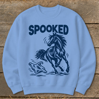 Light blue sweatshirt with navy graphic of a spooked horse running from a ghost and text "SPOOKED".