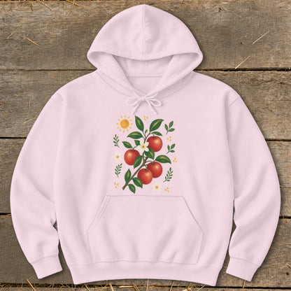 Pink hoodie with a graphic of a branch with red apples, white flowers, and a sun.