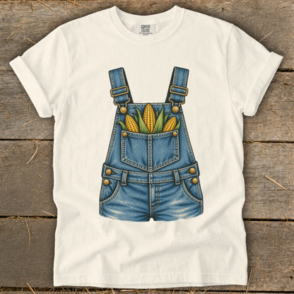 White t-shirt with a denim overalls graphic featuring three ears of corn.