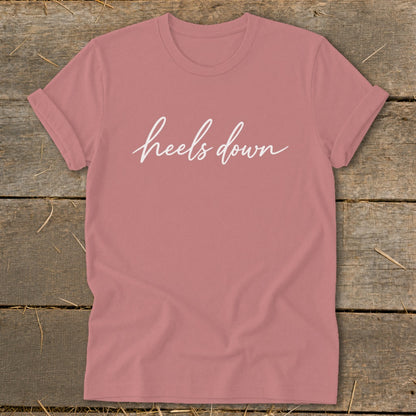 Rose t-shirt with white cursive text that reads "heels down".