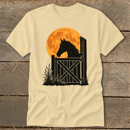 A cream-colored t-shirt with a graphic of a horse's silhouette at a stable gate against an orange moon.