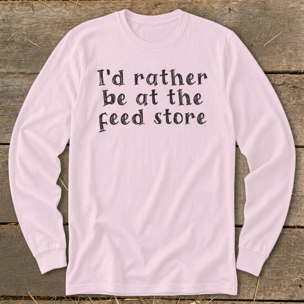 Pink long-sleeve shirt with "I'd rather be at the feed store" text.
