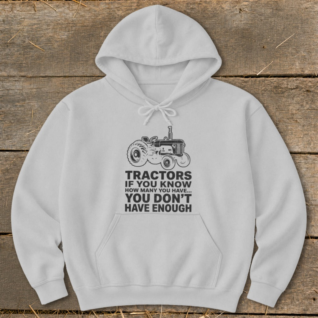 White hoodie with tractor graphic and text "Tractors If You Know How Many You Have... You Don't Have Enough".