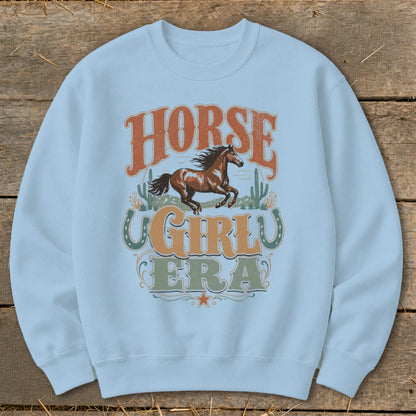 Light blue sweatshirt with "Horse Girl Era" graphic featuring a running horse and cacti.
