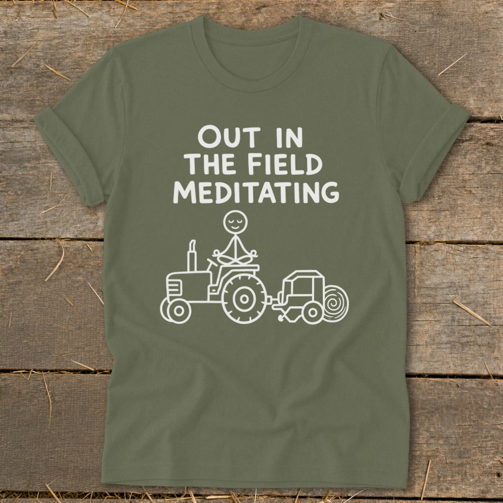 Olive green t-shirt with "Out in the Field Meditating" text and tractor graphic.