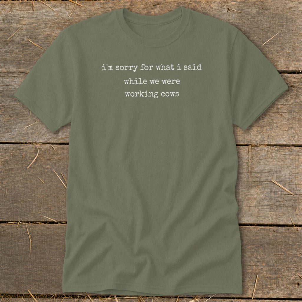 Olive green t-shirt with white text saying "i'm sorry for what i said while we were working cows."