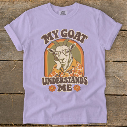 Lilac t-shirt with a retro graphic of a goat wearing glasses and the text "MY GOAT UNDERSTANDS ME".