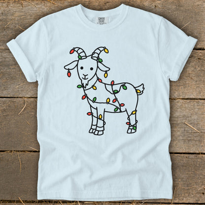 White t-shirt with a cartoon goat wrapped in colorful Christmas lights.