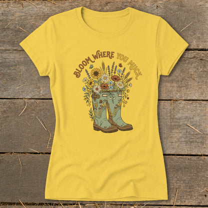 Yellow t-shirt with "Bloom Where You Muck" graphic and floral wellington boots.