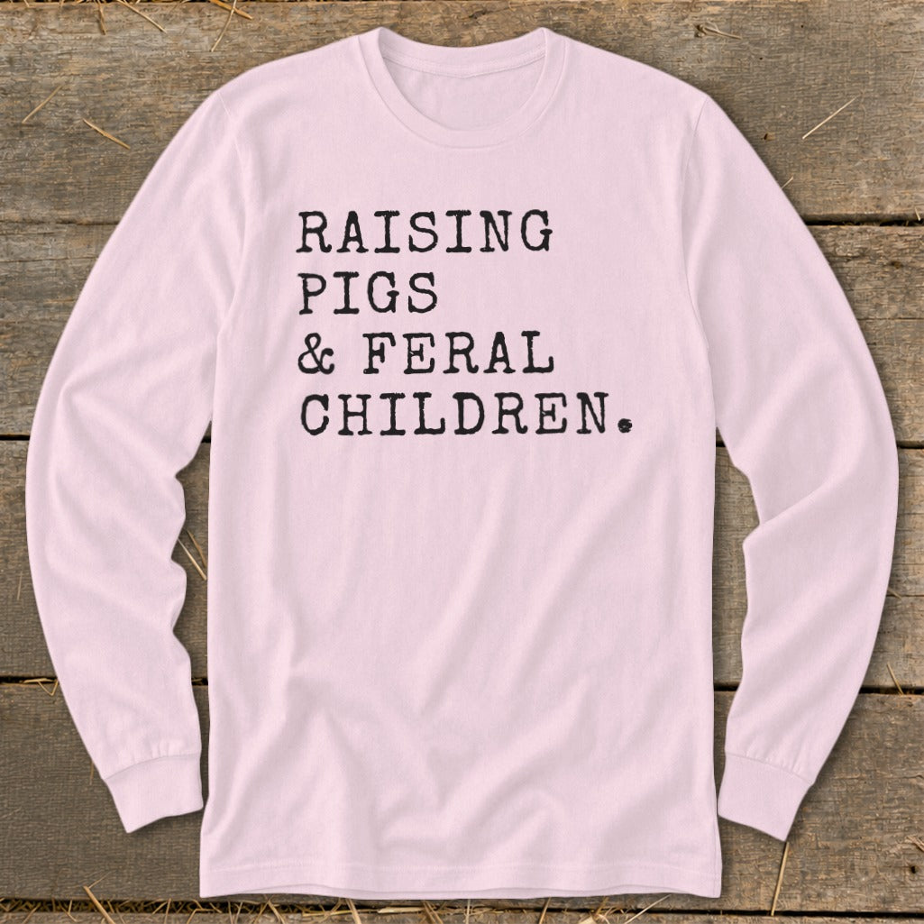 Pink long sleeve t-shirt with black text: RAISING PIGS & FERAL CHILDREN.