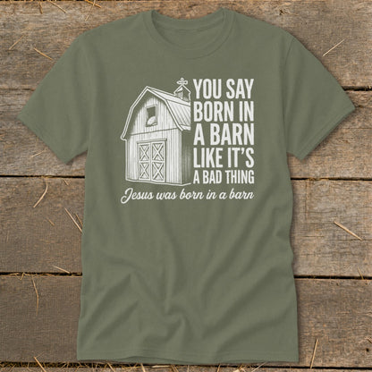 Olive green t-shirt with barn graphic and text "Jesus was born in a barn".