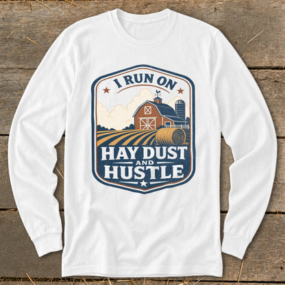 Long sleeve white shirt with a farm scene and text "I run on Hay Dust and Hustle".
