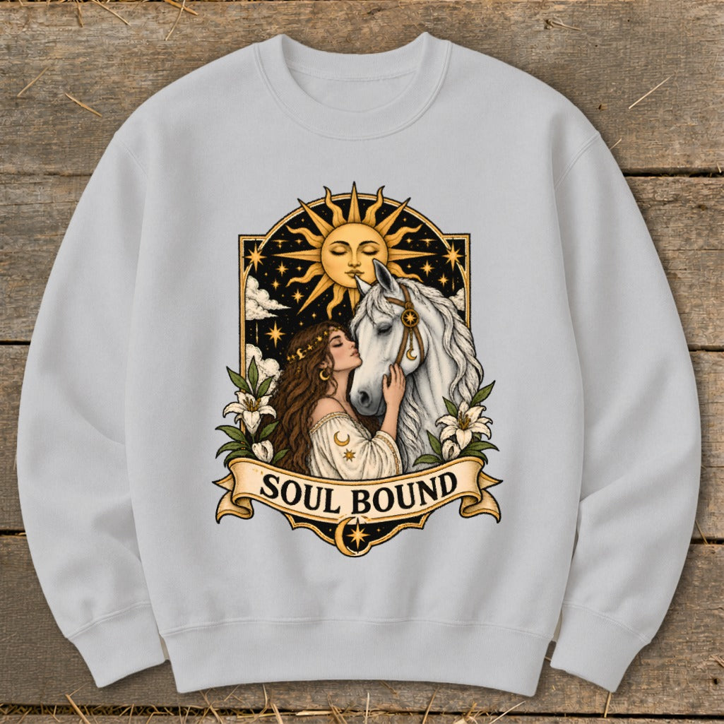 White sweatshirt featuring a "Soul Bound" graphic of a woman and white horse under a sun.